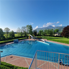 ein+Swimmingpool+mit+einer+Terrasse+und+einem+Berg+im+Hintergrund